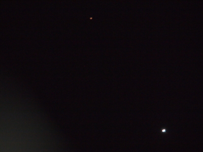 [Mars is a brownish-red orb in the upper middle of the image. Venus is a bright white orb in the lower right of the image. ]